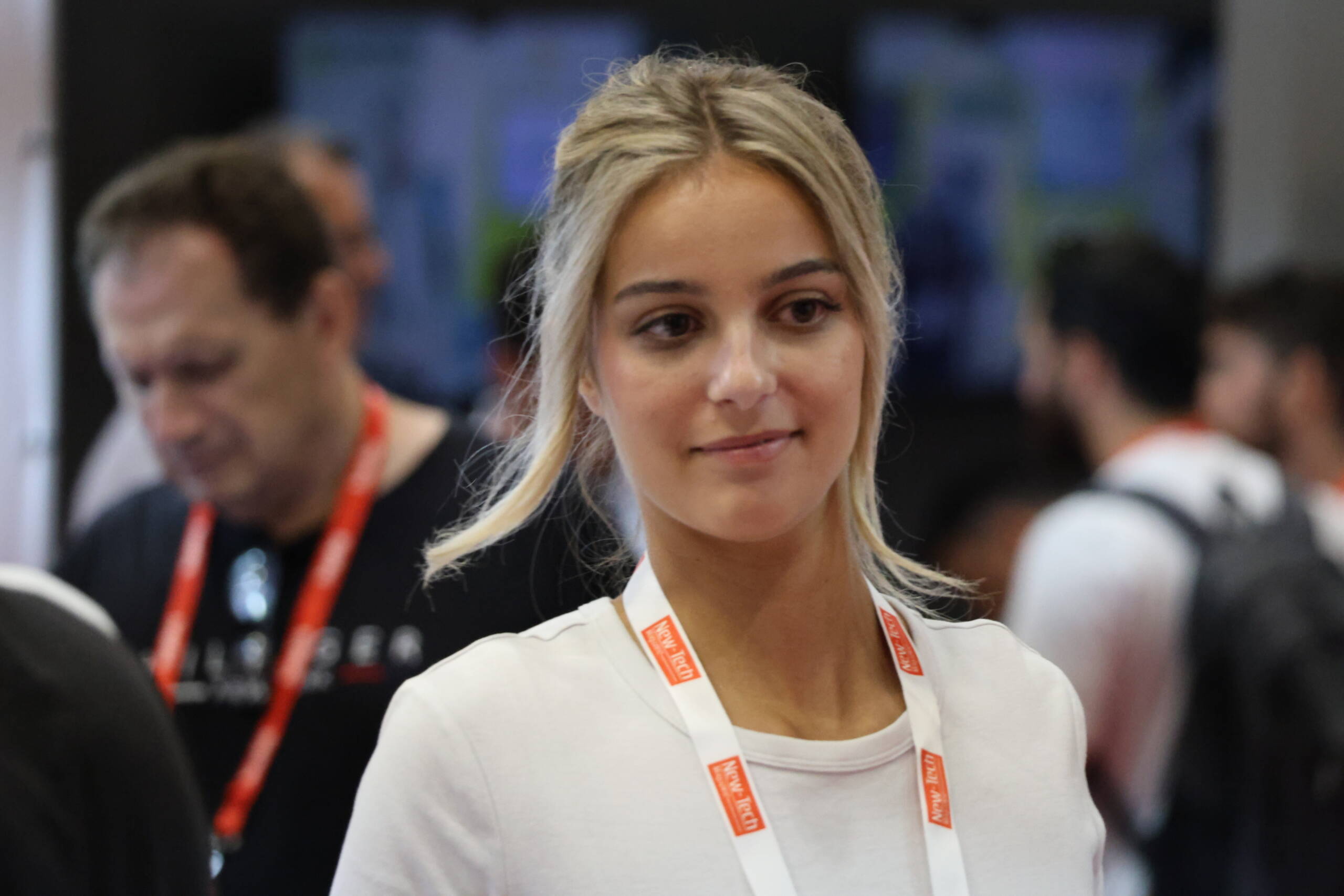 Candid portrait of an attendee at a tech conference, shot with a long lens against a blurred crowd background