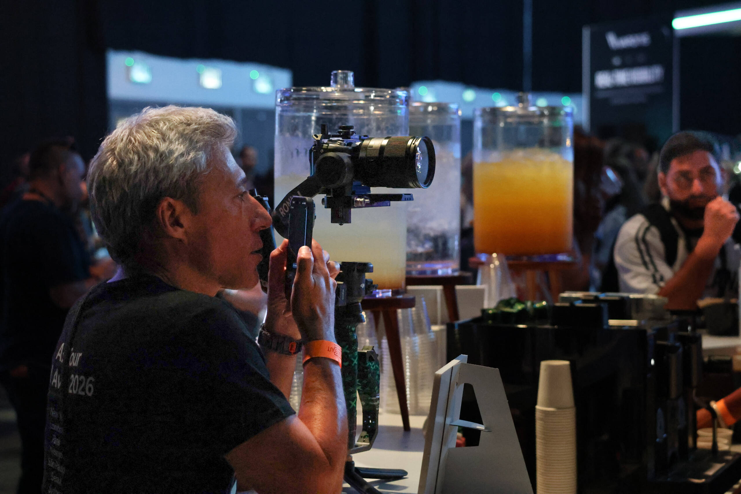 Photographer using a handheld gimbal with a mirrorless camera at an event