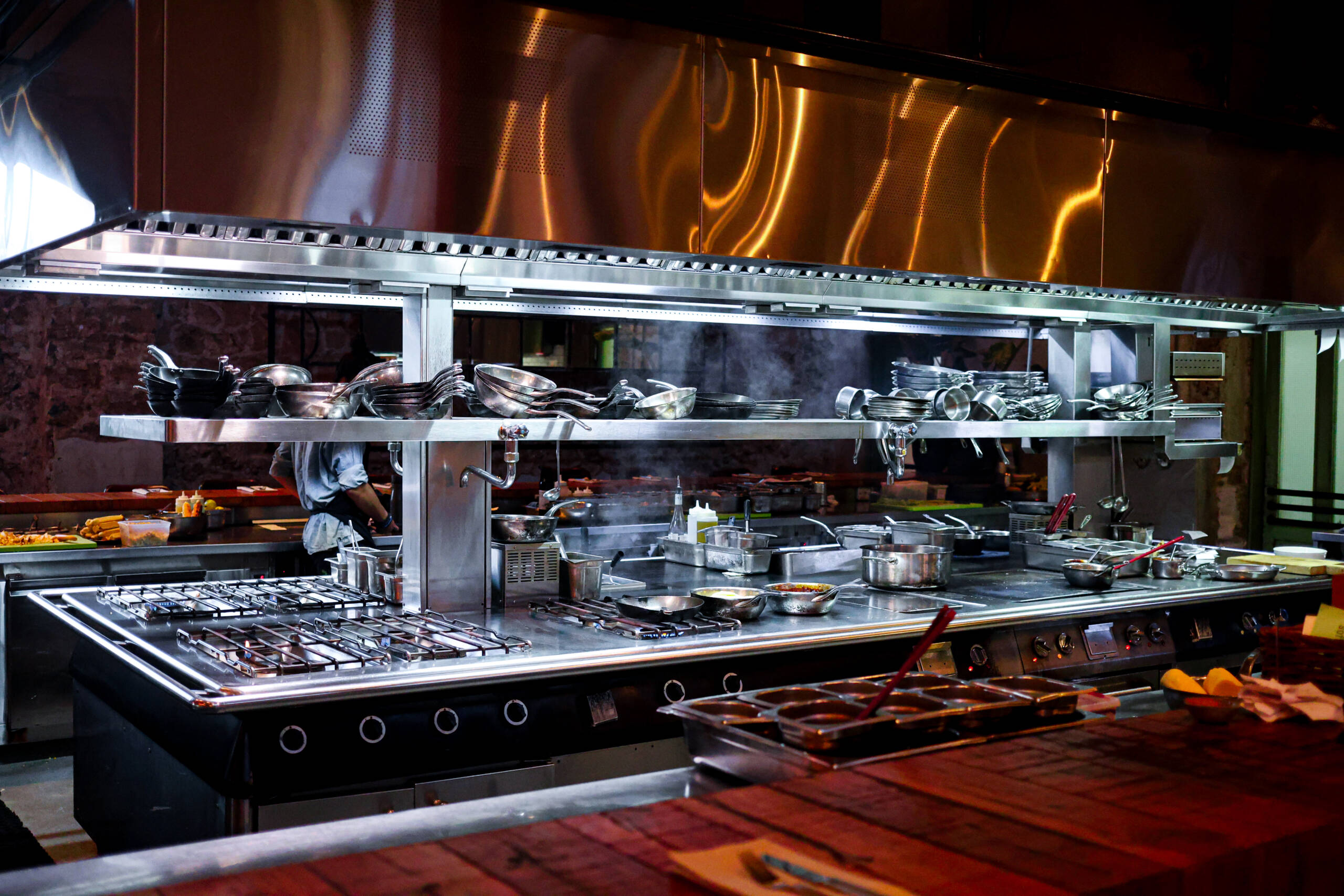 Open kitchen with copper hood and steam
