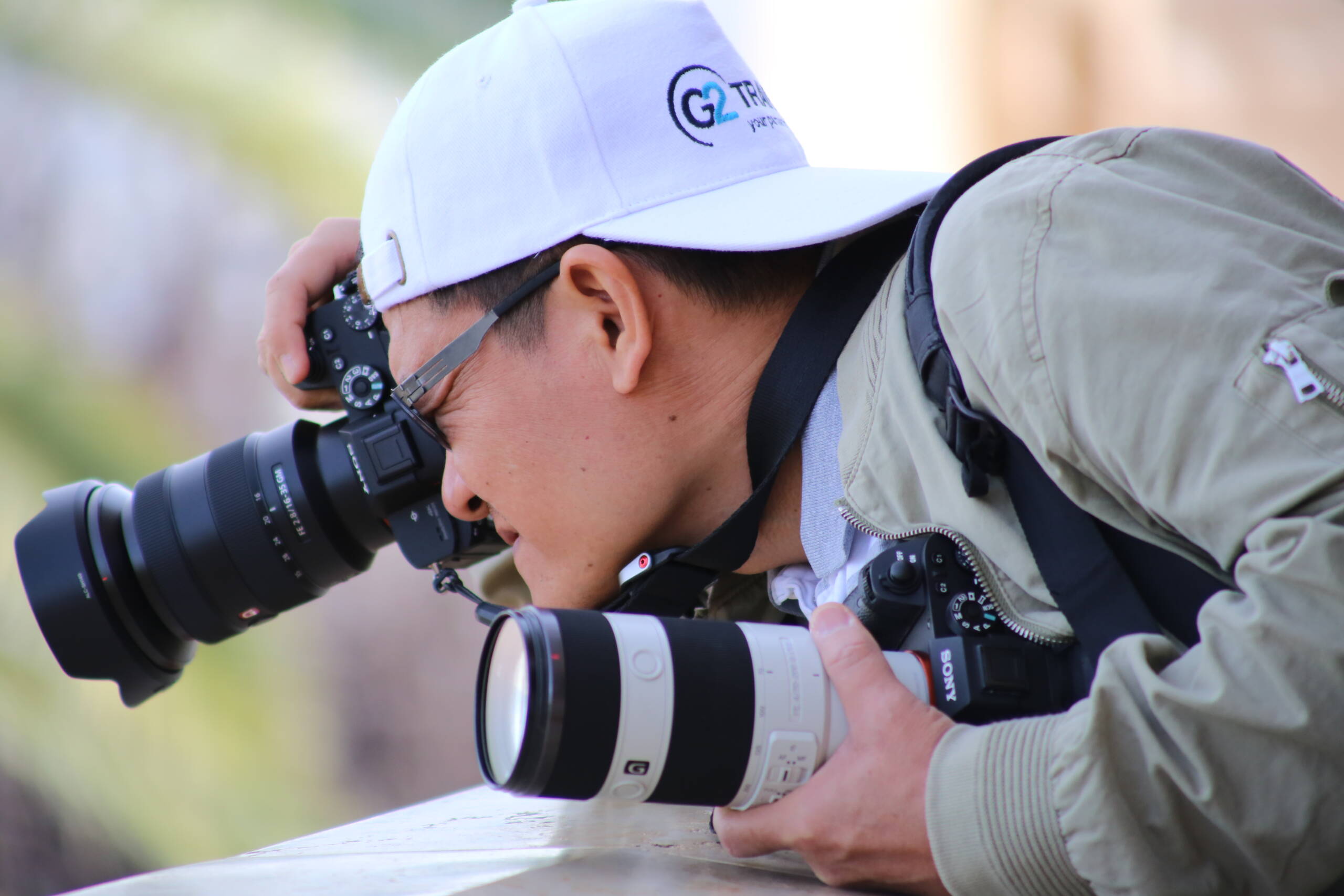 Photographer shooting with a wide zoom on one full-frame body while holding a second body with a telephoto zoom