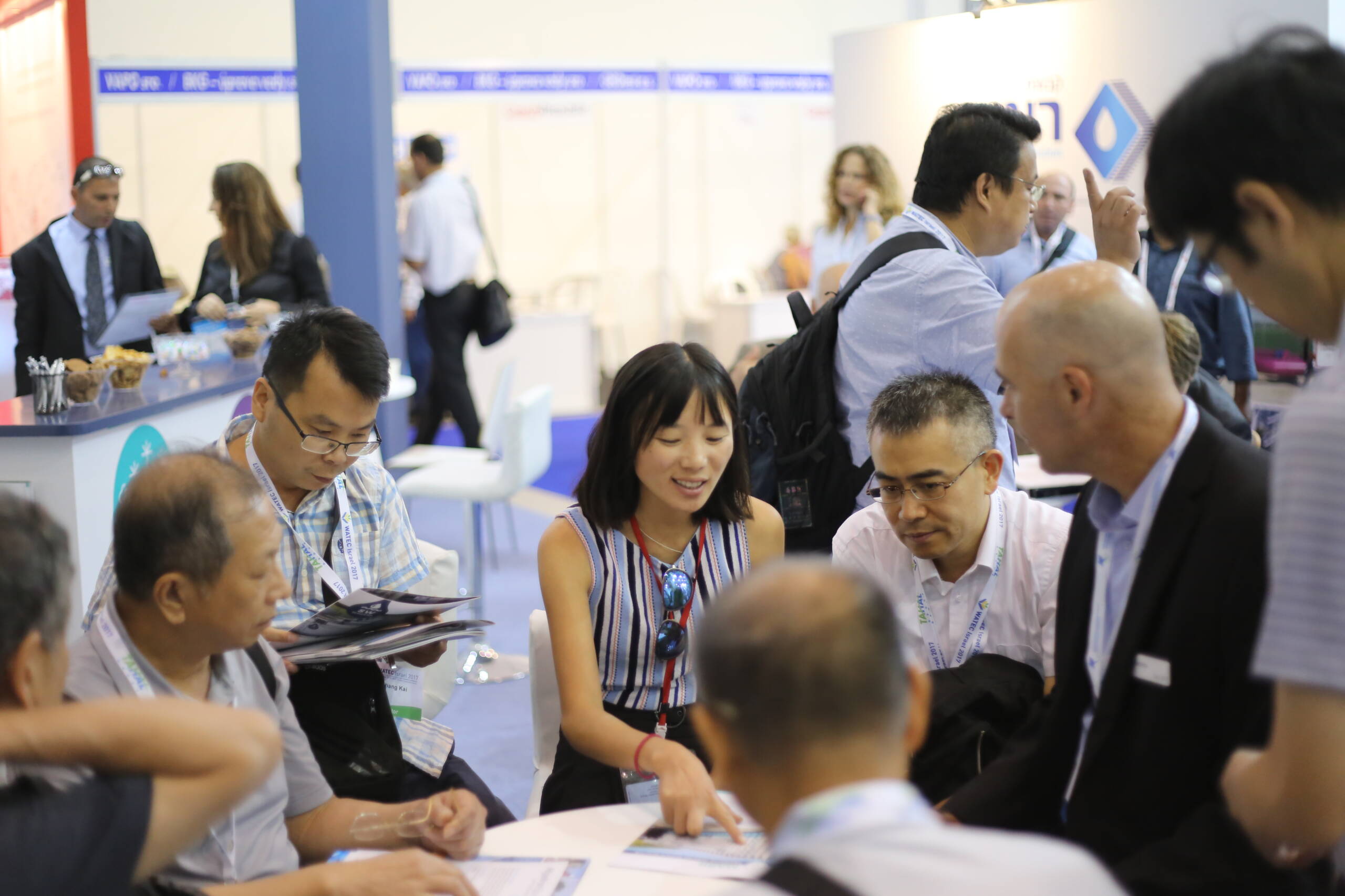 Chinese delegation reviewing brochures at a water technology exhibition booth in Israel