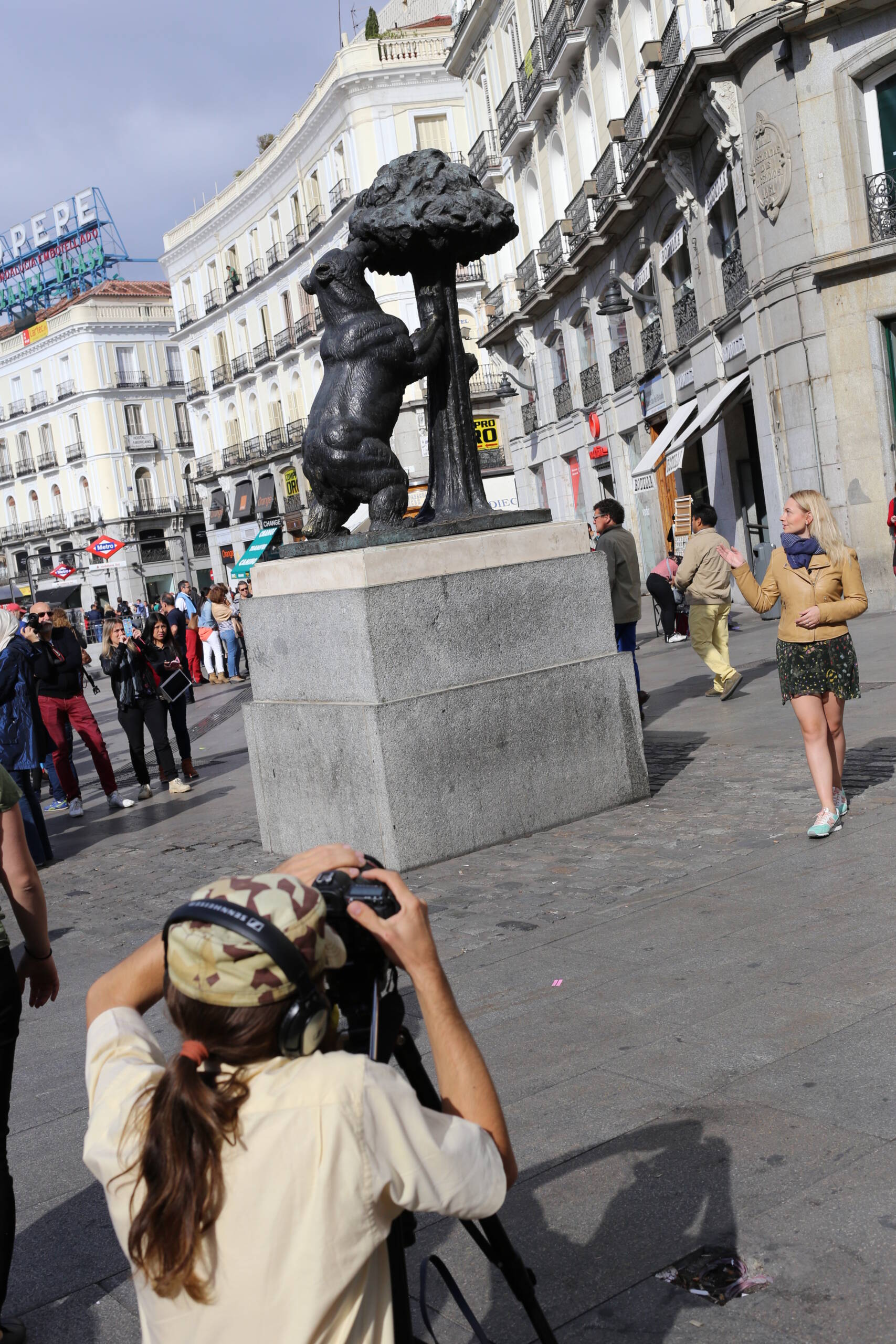 Tourists and a photographer at the Bear and the Strawberry Tree statue in Puerta del Sol, Madrid